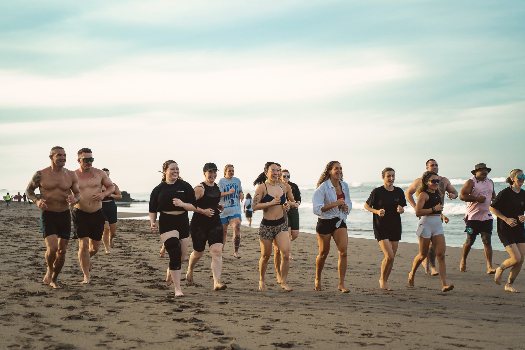 Group running on the beach at dawn